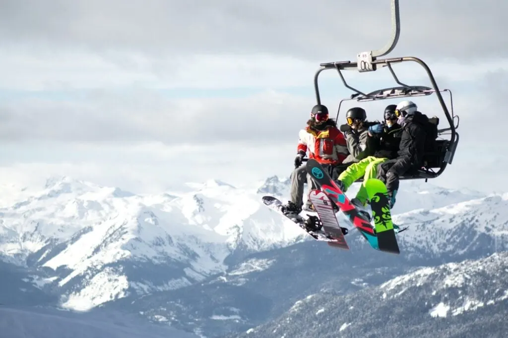 A group of snowboarders ride the lift at Whistler Blackcomb