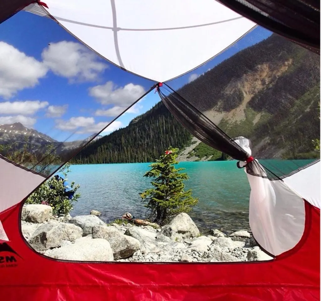 The view through a tent door to a mountain lake