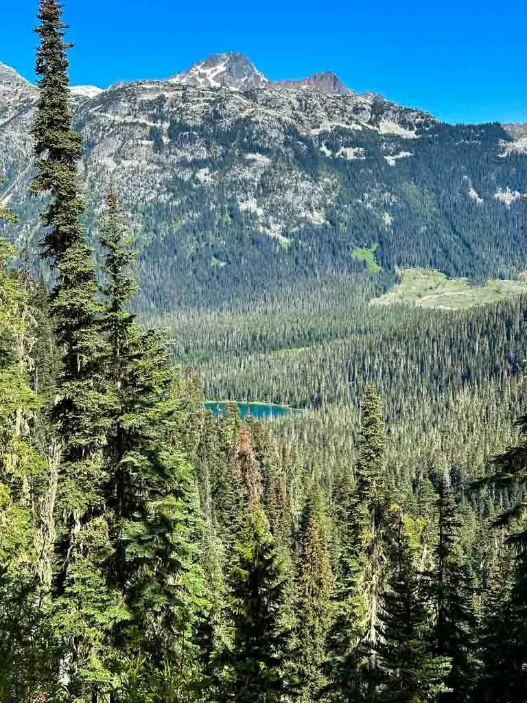 A mountain lake sits below a rocky peak