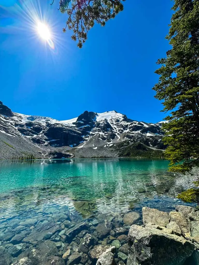 Looking across a glacial blue lake to mountains with glaciers