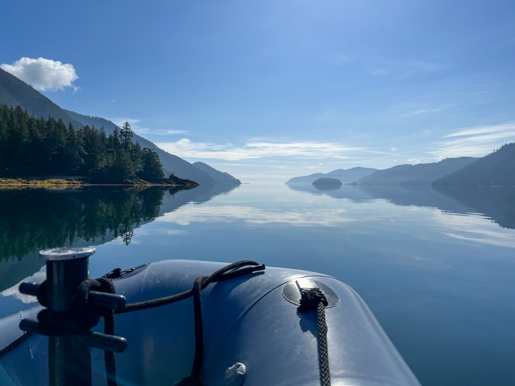 Calm water in front of a boat in Gwaii Hanaas National park
