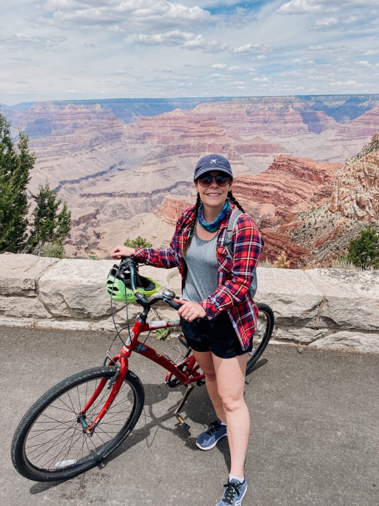 A woman poses with her bike on Hermit Road