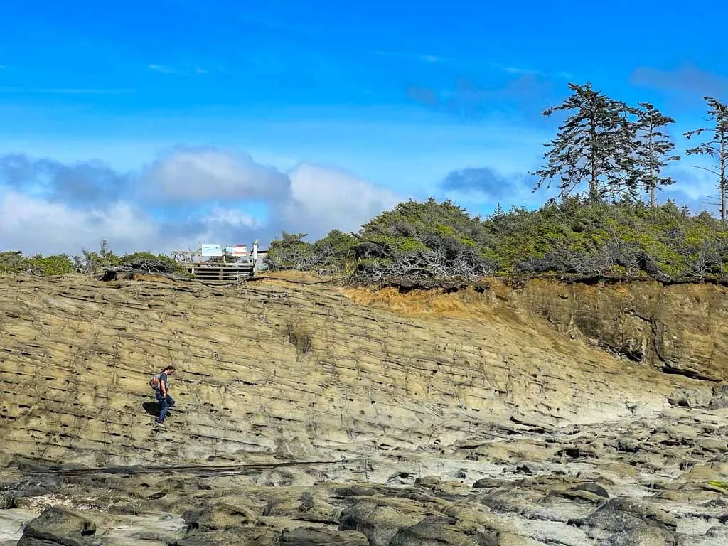 A man hikes along rocks near the Blow Hole in Naikoon Provincial Park on Haida Gwaii