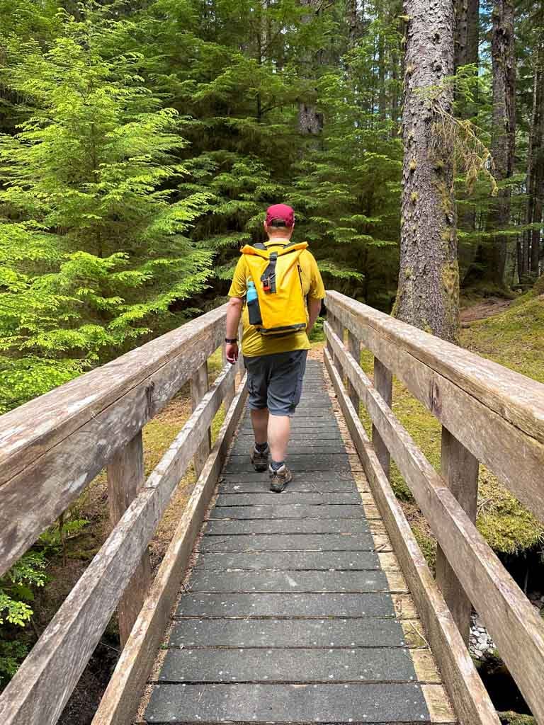 A hiker crosses the wooden bridge over Geikie Creek in Naikoon Provincial Park