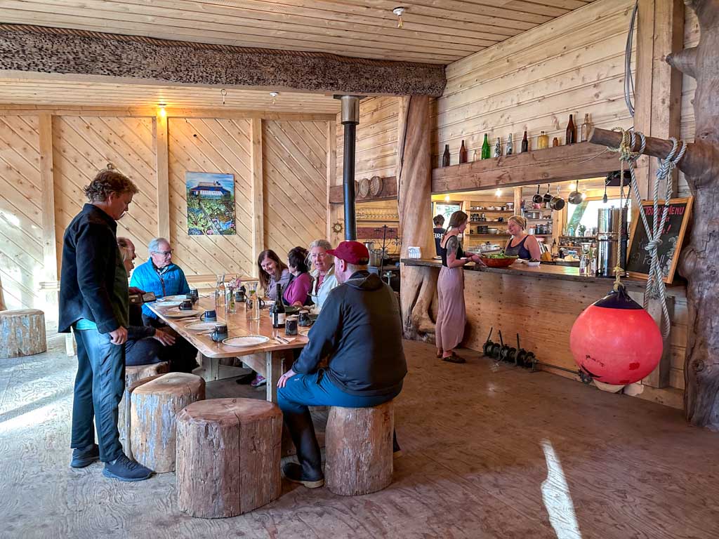 A group of people sits around a table at the cookhouse at Rose Harbour