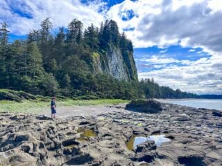 A man standings in front of cliffs at Tow Hill in Haida Gwaii - get the details in this Tow Hill Hiking Guide