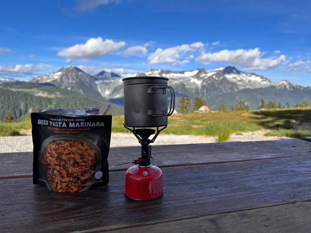 An ultralight cook system on a picnic table in the mountains - how to reduce your backpacking pack weight