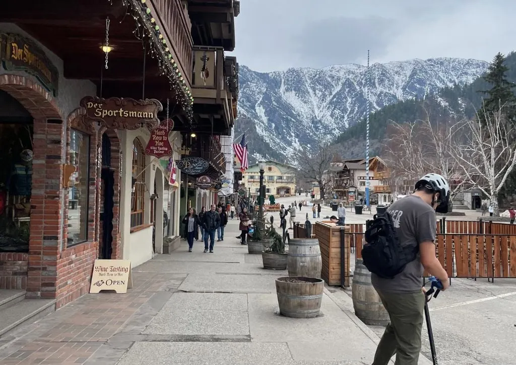 People walk on the streets of Leavenworth Washington with snow on the mountains