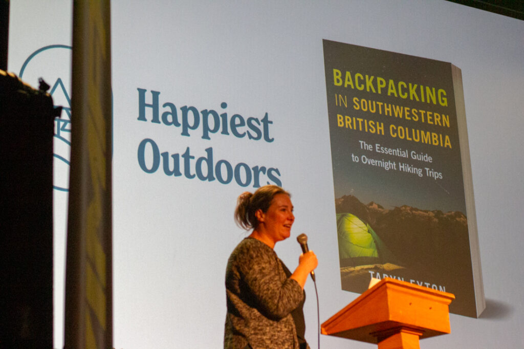 Taryn Eyton speaking on stage at the Vancouver International Mountain Film Festival. 