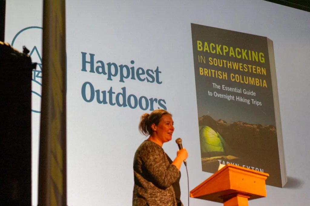Taryn Eyton speaking on stage at the Vancouver International Mountain Film Festival.