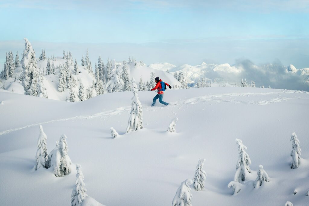A woman in a red jacket snowshoes at Mount Seymour in Vancouver