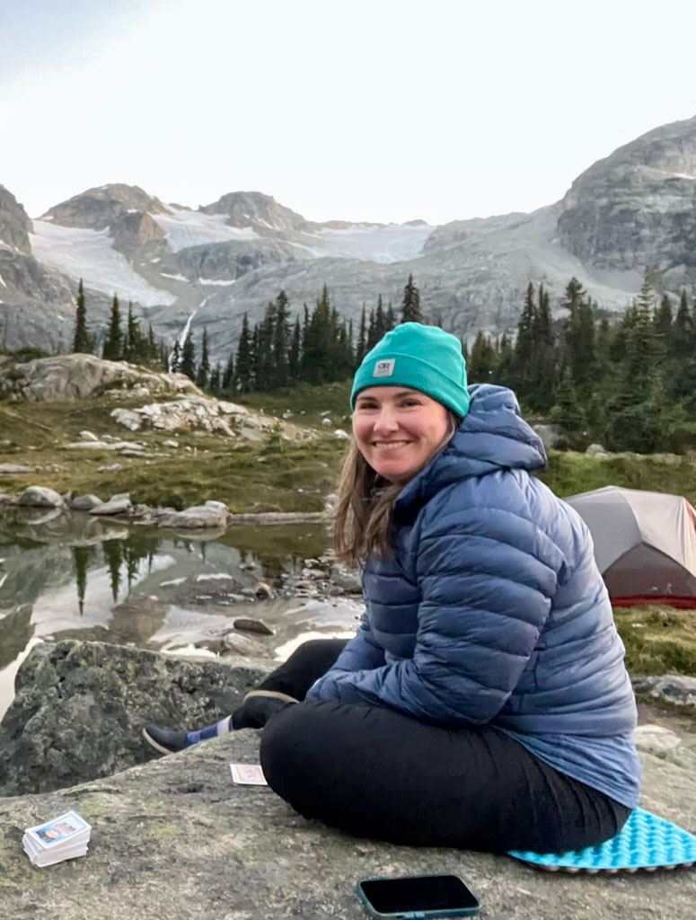Taryn wears the Arc'teryx Cerium hoody to stay warm at a backpacking campsite