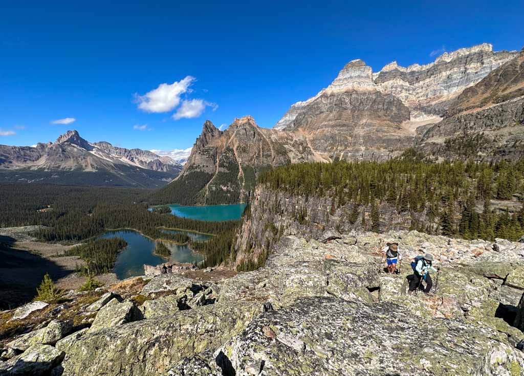 Two hikers walk through rocks on the All Soul's Route at Lake O'Hara