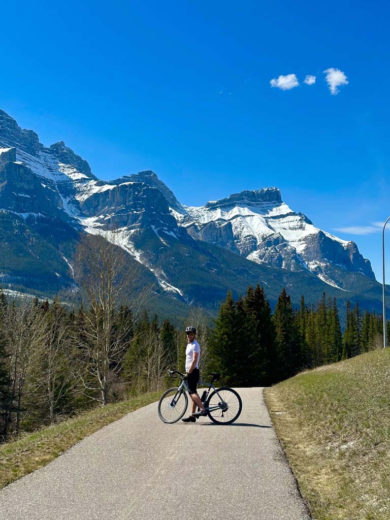 A cyclist poses on the Banff Legacy Trail - one of the best things to do in Banff in the spring