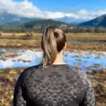 A woman wears a Merino wool shirt on a hike. Is Merino wool worth it?