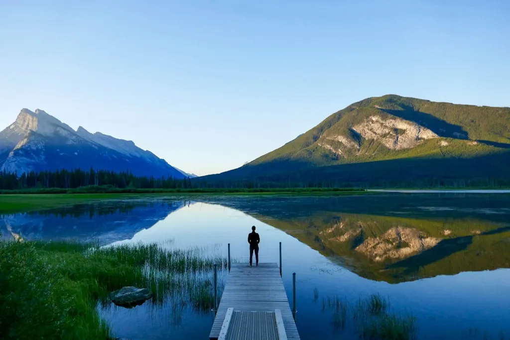 A person stands on the dock at Vermilion Lakes in Banff