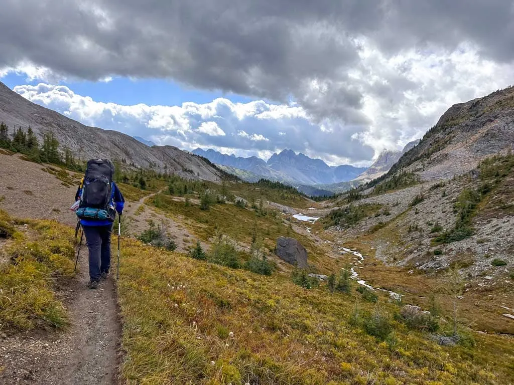 A hiker walks on a narrow trail through Wonder Pass in Banff National Park