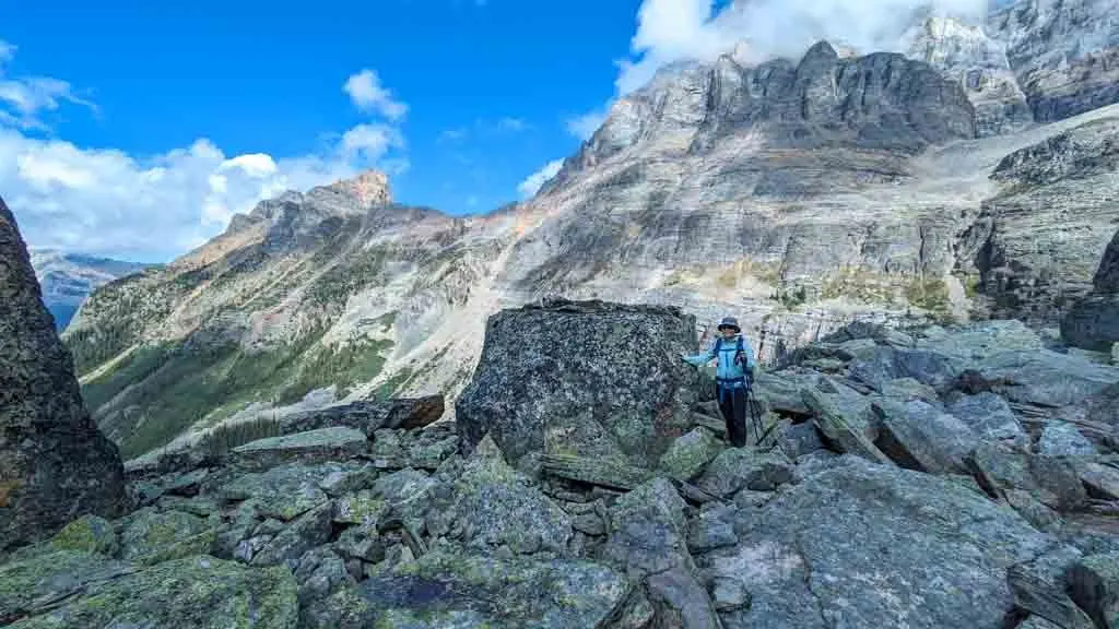 A hiker stands next to a large boulder in Yoho National Park