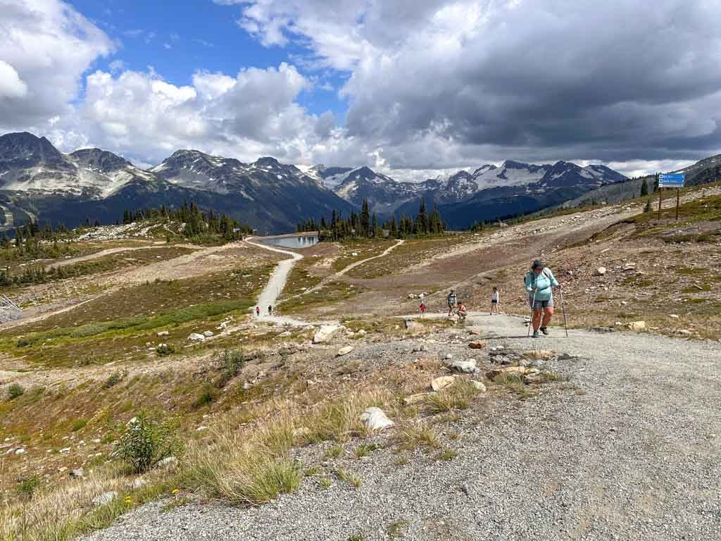 Hikers walk up a gravel trail on Whistler Mountain