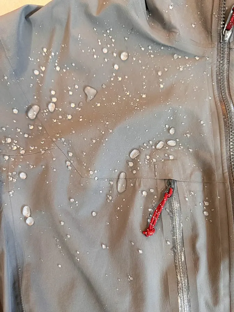 Water droplets beading up on a rain jacket with a fresh DWR coating