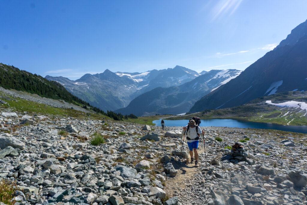 A hiker with a backpack climbs up the trail from Russet Lake