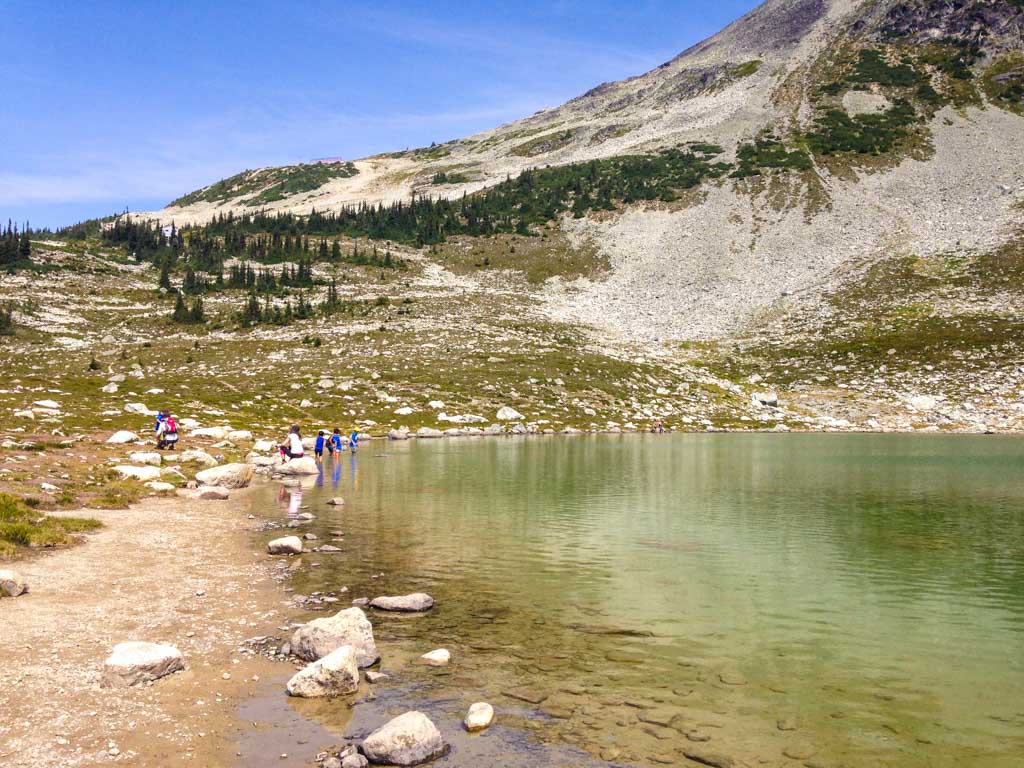 Hikers dipping their feet into Blackcomb Lake