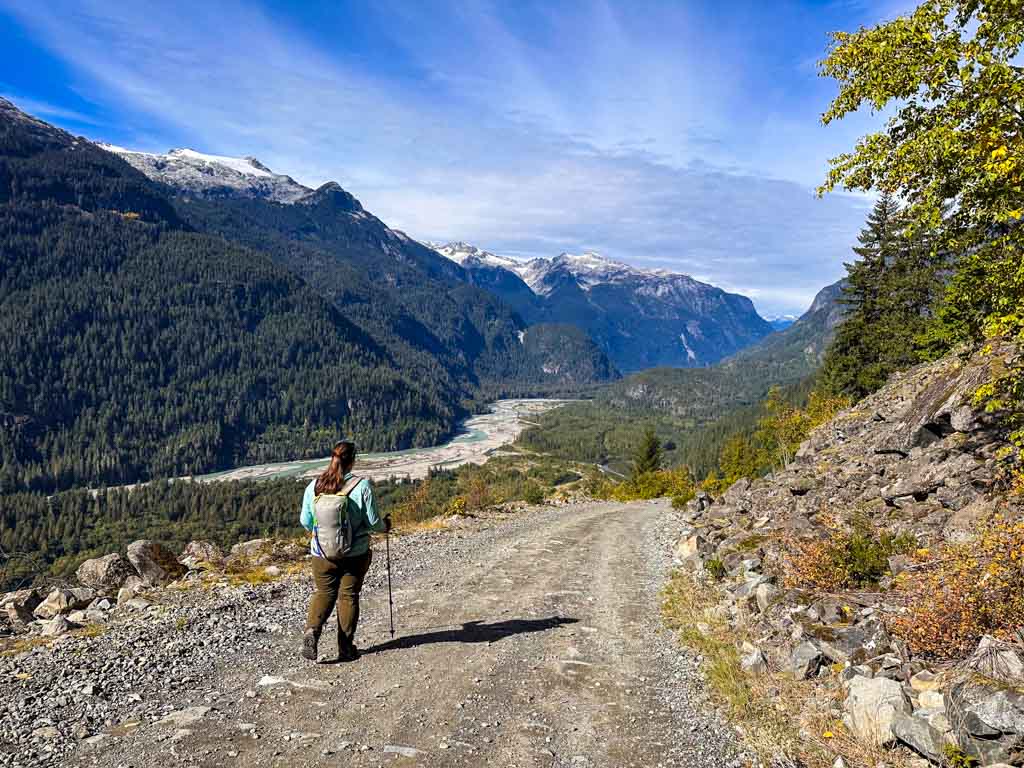 A woman walks down a gravel road high above the Squamish River