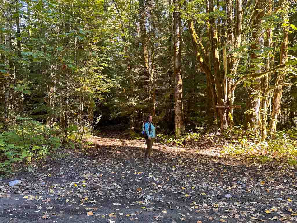 A woman stands at the High Falls Creek Trailhead in Squamish