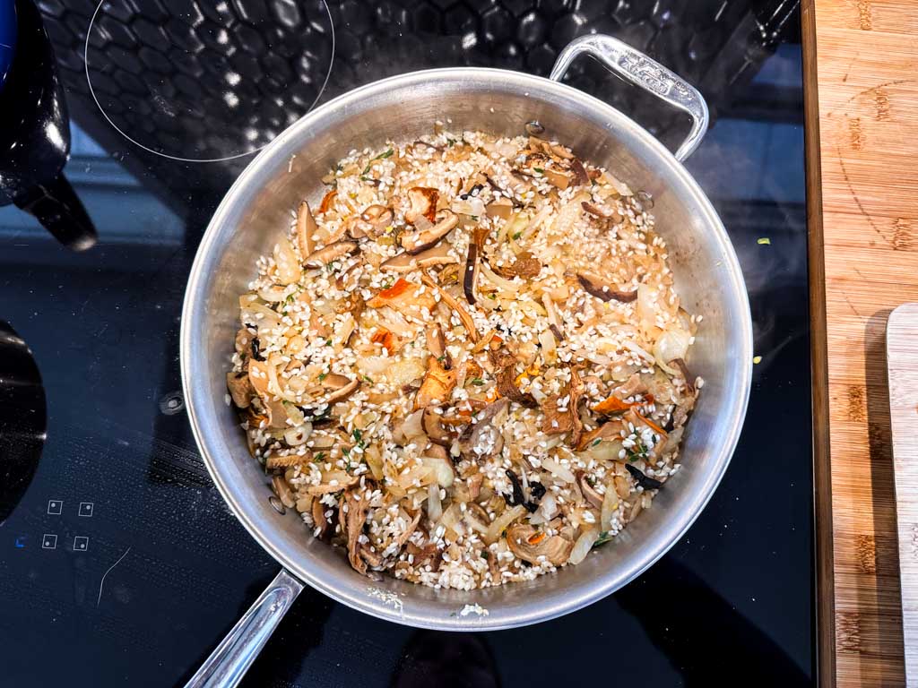 Mushroom risotto cooking in a steep sided skillet