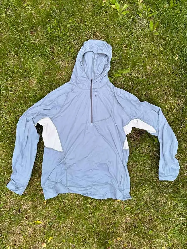 Black Diamond Alpenglow Pro sun hoodie laying flat on grass