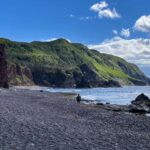 A man hikes on a rocky beach on the Green Gardens Trail in Gros Morne National Park in Newfoundland