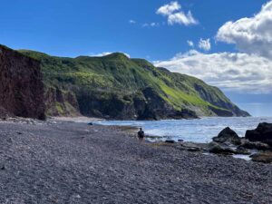 A man hikes on a rocky beach on the Green Gardens Trail in Gros Morne National Park in Newfoundland