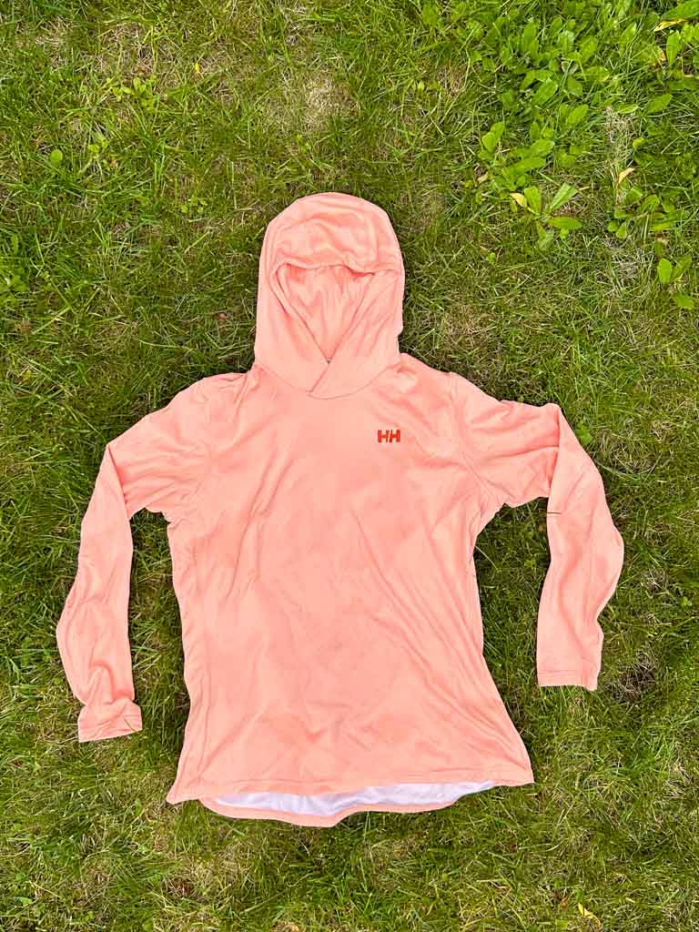 The Helly Hansen Solen Lifa Active Hoodie laying flat on grass