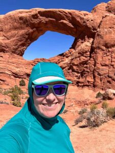 A close up of a hiker wearing the Outdoor Echo Hoodie with the hood up in Arches National Park