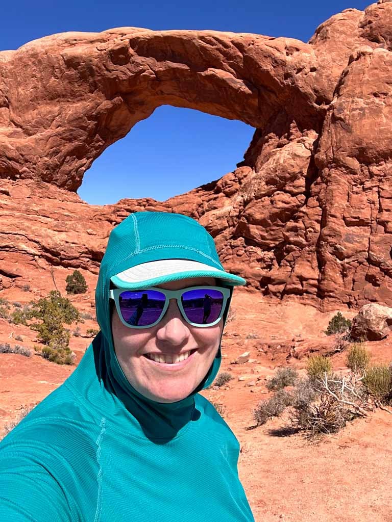 A close up of a hiker wearing the Outdoor Echo Hoodie with the hood up in Arches National Park