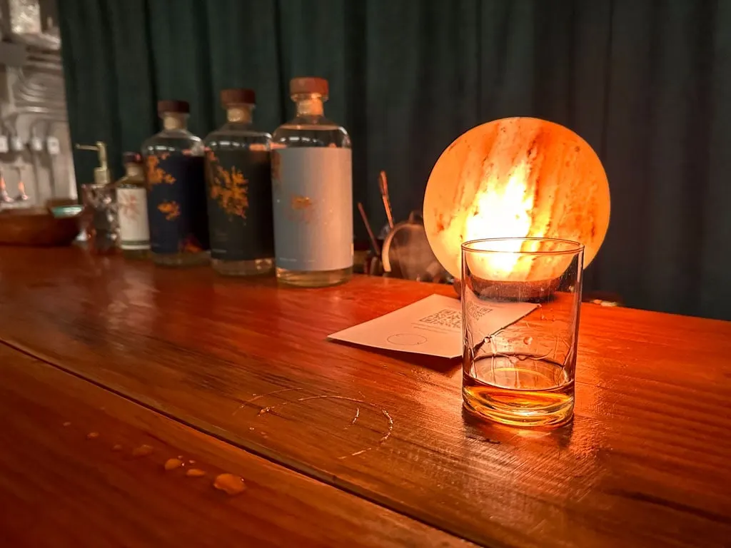 A glass of whisky on a wooden bar at Copper Spirit Distillery