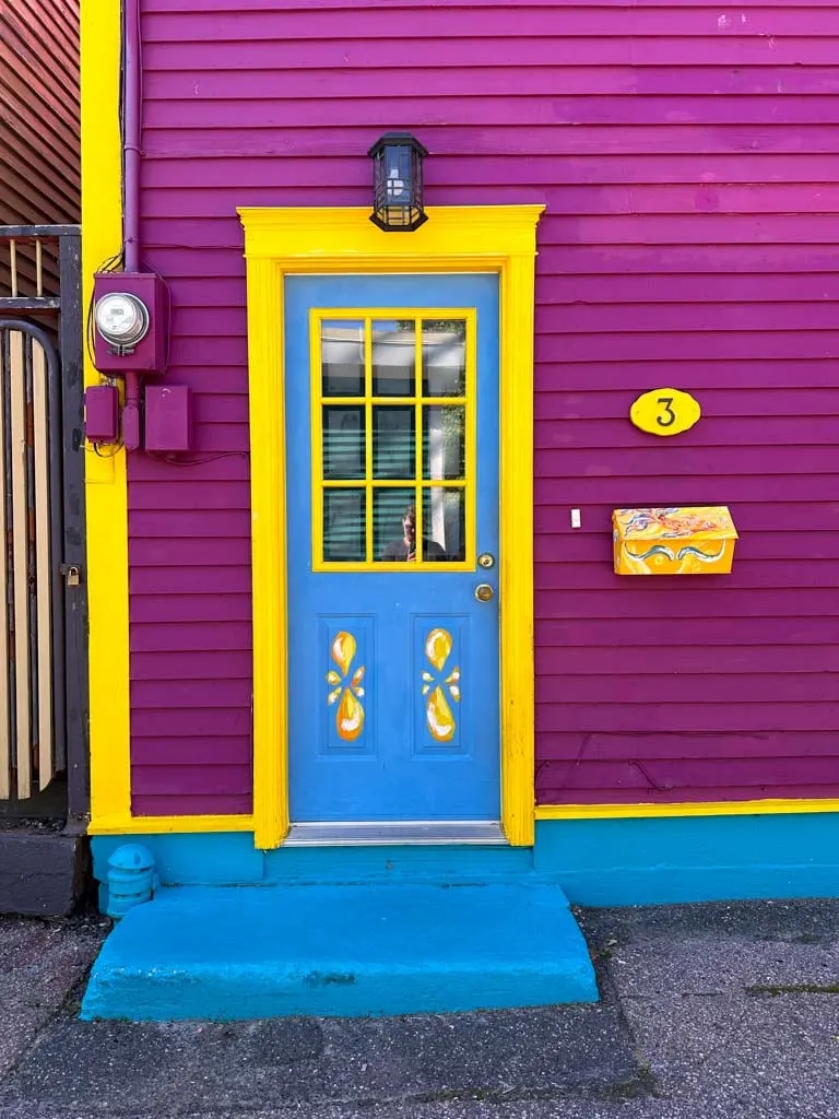 Close up of a blue and yellow door on a purple house in the Jellybean Row neighbourhood