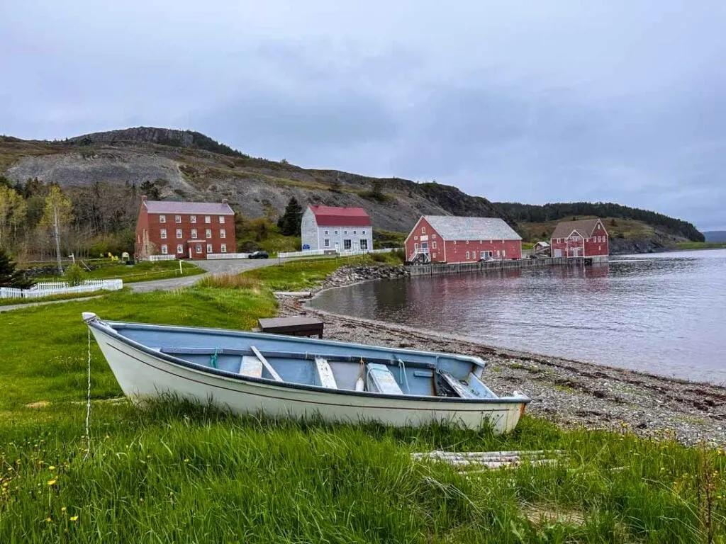 A boat sits in the grass in front of the Lester-Garland Premises in Trinity