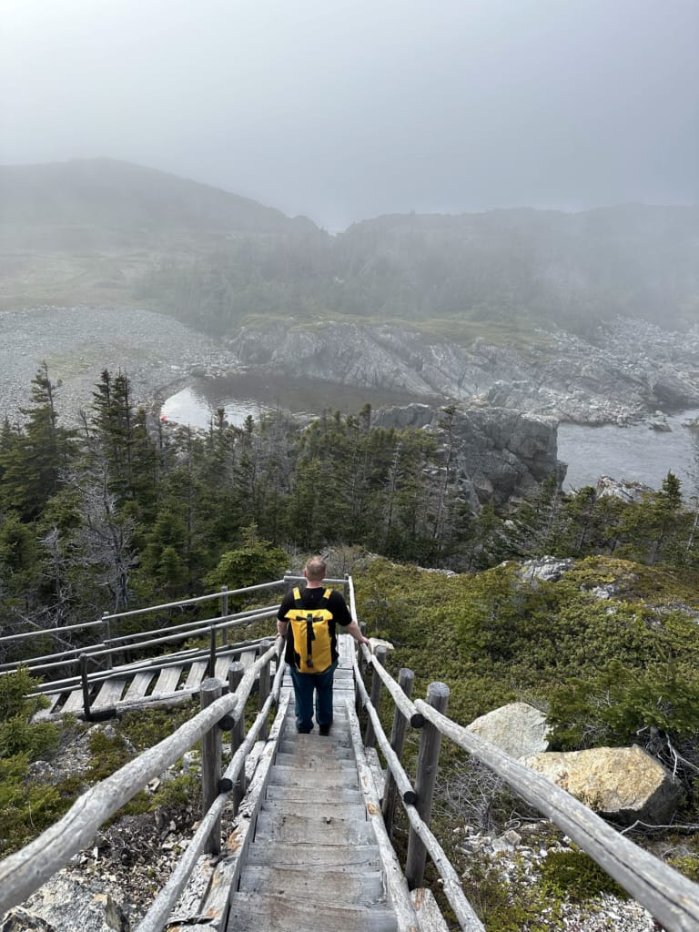 A hiker walks down the stairs on the Little Harbour Trail, one of the Rockcut Trails