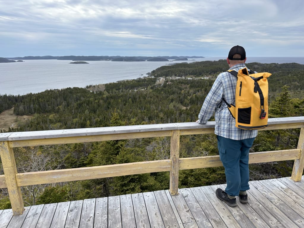 A hiker enjoys the view on the Top of Twillingate Trail
