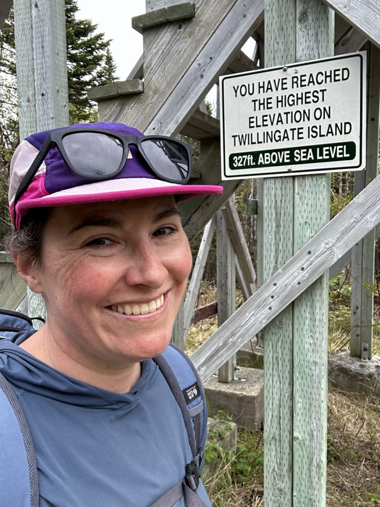 A hiker takes a selfie at the Top of Twillingate Sign