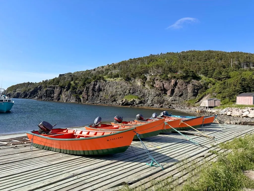 Small handmade wooden fishing boats sit on the dock at Little Port, Newfoundland