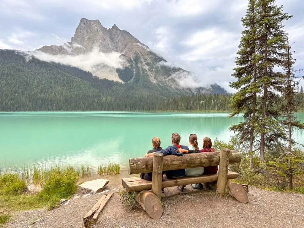 A family sits on a bench along the Emerald Lake Trail