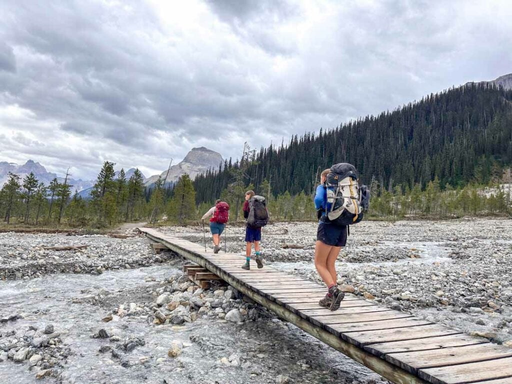 Hikers cross a bridge near the Takakkaw Falls Campground