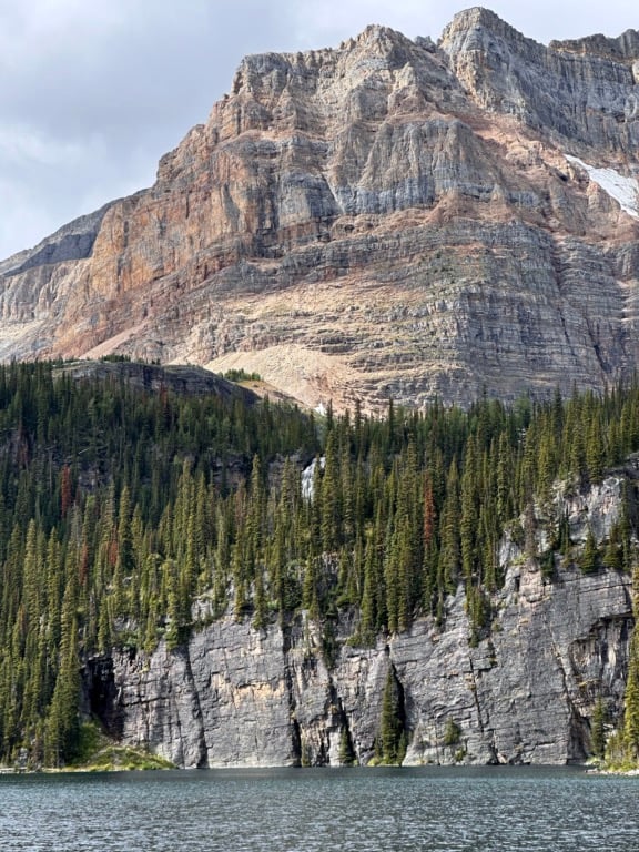 A waterfall obscured by trees flows into Egypt Lake