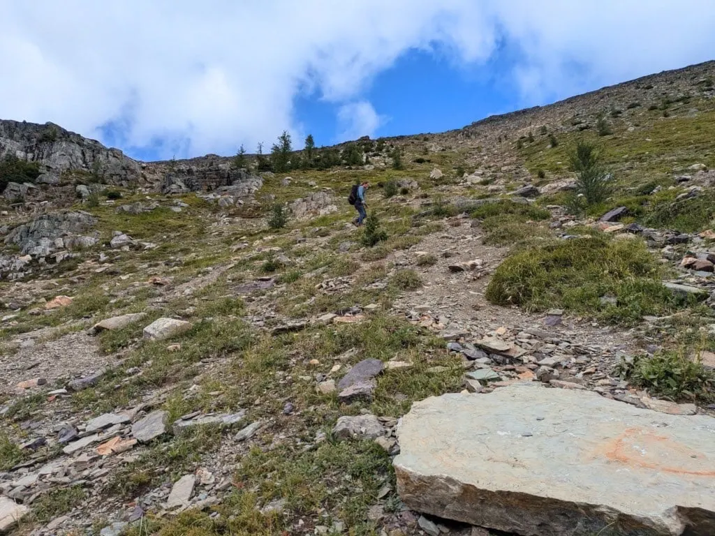 A hiker makes their way up the scramble route to Pharaoh Peaks