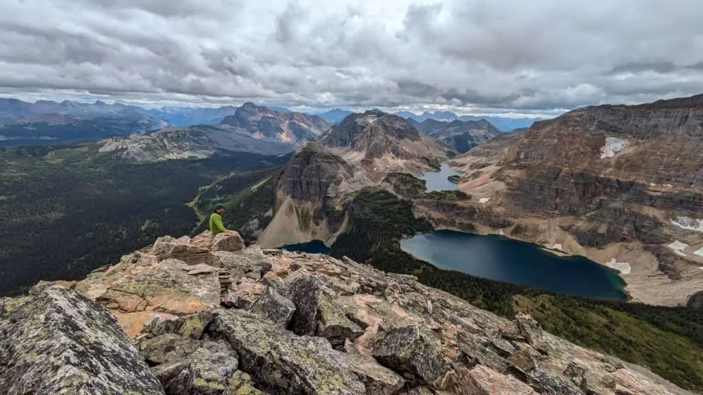 A hiker enjoys the view from the summit of Pharaoh Peaks