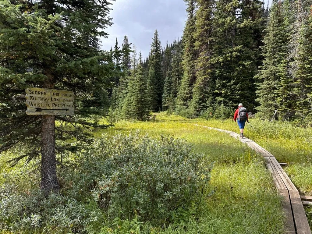 A hand-carved trail sign shows the way to Scarab Lake, Mummy Lake, and Whistling Pass