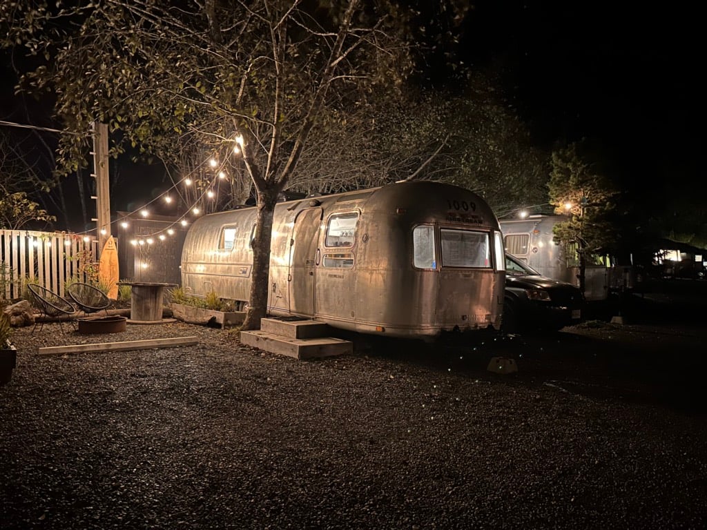 An airstream trailer at night with a string of white lights at the Mackenzie Beach Resort. 