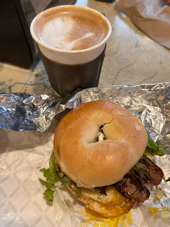 A breakfast sandwich and coffee on a table at Rhino Coffee in Tofino